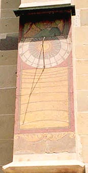 sun dial on church wall